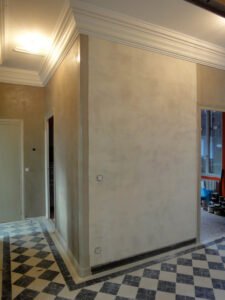 Mur en stuc à la chaux finition nuagée dans une entrée avec sol en damier noir et blanc – réalisation Décors & Matières.
